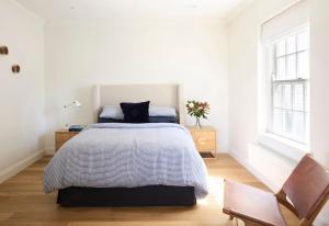 a white bedroom with a bed and a chair at Hazelwood House in Mittagong +29 photos