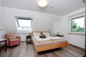 une chambre avec un lit, une chaise et une fenêtre dans l'établissement Neu renovierte Dachgeschosswohnung, à Bad Wurzach