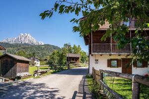 a road in a village with a mountain in the background at Cuore delle Dolomiti in Tonadico