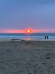 Dos personas caminando por la playa al atardecer en sun sea 白浜大浜海水浴場 コンビニ徒歩1分, en Shimoda
