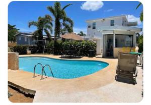 een zwembad voor een huis bij White House Paradises in Cabo Rojo
