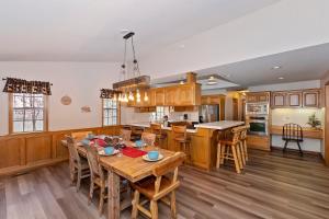 Una cocina con gabinetes de madera y una mesa con sillas. en 118 - Pinecrest Getaway - Big Bear Getaway, en Big Bear Lake