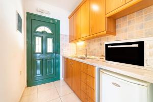 a kitchen with a green door and a sink at Spyridoula Studio 13 in Paleokastritsa