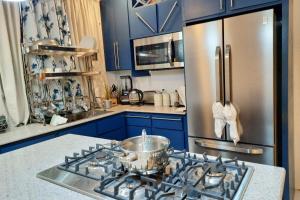 Baboon IslandVilla View -Cozy Retreat的厨房配有蓝色橱柜和不锈钢冰箱