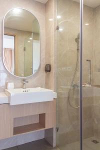 Gò CôngにあるNice Homeの洗面台と鏡付きシャワーを備えたバスルーム