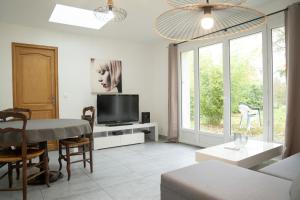 a living room with a table and a tv at Individual Guest House - Between Paris and Disneyland in Vaires-sur-Marne