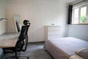 a bedroom with a desk and a bed and a desk chair at Individual Guest House - Between Paris and Disneyland in Vaires-sur-Marne