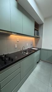 y cocina con fregadero y fogones. en Studio Live 2 Moderno e Aconchegante, en Uberlândia