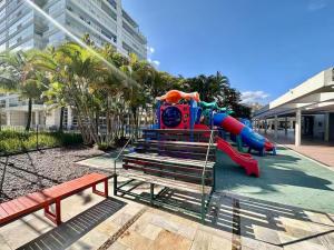 ein Spielplatz mit Wasserrutsche in einem Park in der Unterkunft Apartamento para aluguel de temporada in Bertioga