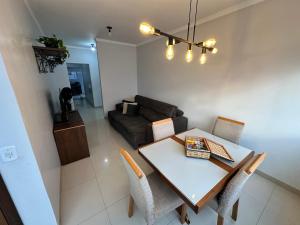 a living room with a table and chairs and a couch at Apto próx Hospital Regional até 6 pessoas com garagem e wifi in Nova Mutum +38 photos