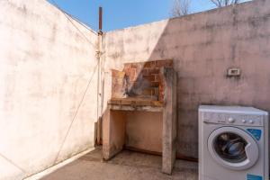 トッレ・スペッキア・ルッジェーリにあるAppartamento Amare 1のコンクリートの壁の横に置かれた洗濯機