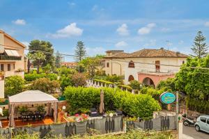 ジャルディーニ・ナクソスにあるChiara Home Apartmentの庭園と建物のあるヴィラ