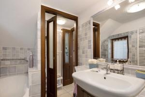 une salle de bain avec un lavabo, une baignoire et un miroir dans l'établissement Da Manu - Blavy Nus, à Blevy 19 autres photos