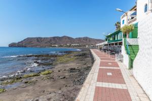a walkway along the beach in front of a building at Apartamento Las Playitas in Tuineje +12 photos