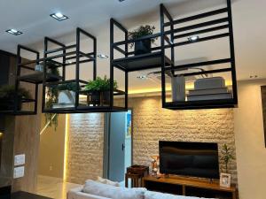 a living room with black shelves and a tv at Lindo Apartamento Cop30 in Belém +37 photos