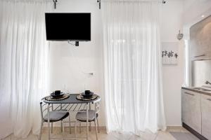 a kitchen with a table with two chairs and a television at Edda's apartment in Altare
