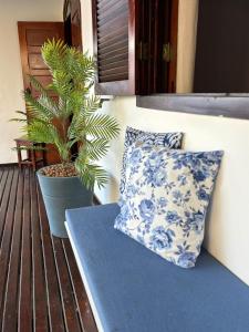 アハイアウ・ド・カボにあるFlor de Alissah Pousada & Bistroの青と白の枕とベンチの上の植物