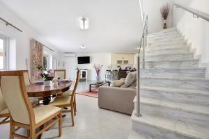 uma sala de estar com uma mesa de jantar e uma escadaria em Lugar Encantador em Alvor