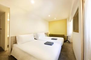 two white beds in a hotel room at Holiday Inn & Suites Sapporo Odori Park by IHG in Sapporo +101 photos