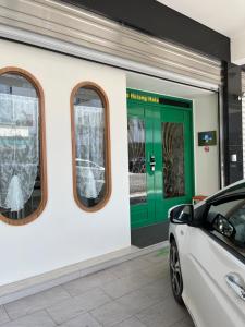 a car parked in front of a green door at Daisy's Hsiang Hola in Chiayi City