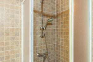 a shower with a shower head in a bathroom at Villaggio Anemone - Chalet Mirtillo in Capanne di Sillano +22 photos