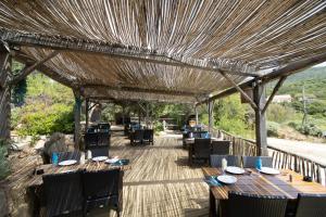 コティ・シアヴァーリにあるLe Chalet De La Plageの木製のテーブルと椅子が備わる屋根のレストラン