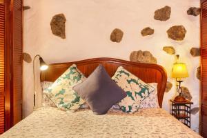 a bedroom with a bed with rocks on the wall at Casita Roque Nublo in Tejeda