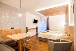 a bedroom with a bed and a table and chairs at Chalet Osmar Suite 2 in Campitello di Fassa