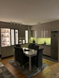 a kitchen with a table and chairs and a kitchen with green at Lux Star Belgrade in Belgrade