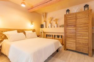 a bedroom with a white bed and a wooden cabinet at Sublime Appartement Centre D’aix in Aix-en-Provence