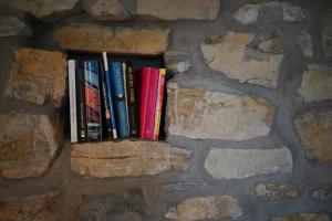 a row of books sitting on a stone wall at Antico Podere Carbone in Grosseto