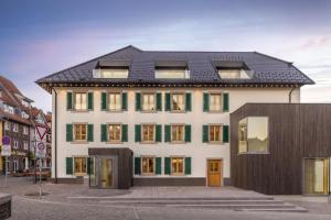 a large white building with a black roof at Apartments Bären in Elzach +78 photos