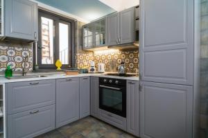 a kitchen with white cabinets and an oven at A Ugghia- I Mori in Fiumefreddo di Sicilia +16 photos
