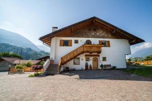 a large white house with a wooden roof at Langeshof Fewo Abendrot in Caines