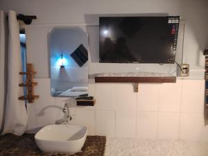 ウユニにあるCABAÑAS SAL y PIEDRAのバスルーム(トイレ付)、壁掛けテレビが備わります。