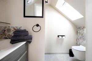 une salle de bain avec un lavabo, des toilettes et un miroir dans l'établissement Uhses Ferienwohnung, à Heide 15 autres photos