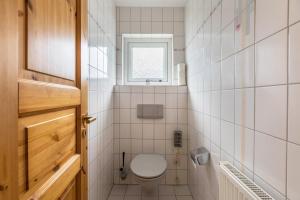 une petite salle de bain avec toilettes et fenêtre dans l'établissement Ferienhaus Herich, à Nieblum 22 autres photos