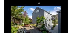 a large white house with plants in a yard at Miners Lane Guest House in Clyde