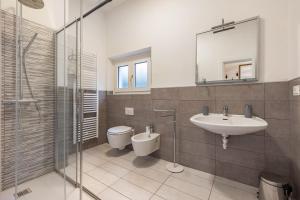 a bathroom with a sink and a toilet and a mirror at Tanas in Tenno +32 photos