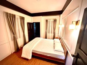 シロンにあるRoy-al Homestay 2の部屋に白いベッドがある寝室