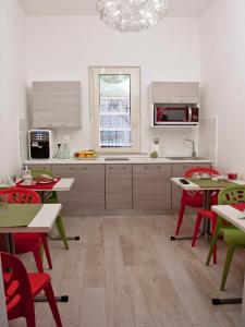 アルバ・アドリアティカにあるAlba D'Abruzzo Bed and Breakfastの赤い椅子とテーブル付きのキッチン