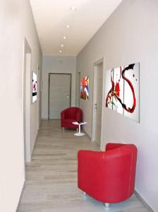 アルバ・アドリアティカにあるAlba D'Abruzzo Bed and Breakfastの赤い椅子と壁画のある廊下