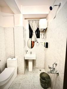 シロンにあるRoy-al Homestay 2の洗面台とトイレを備えた白いバスルーム