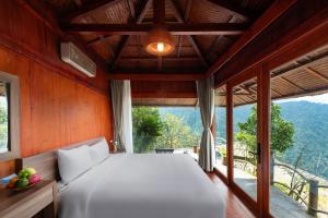 a bedroom with a bed and a large window at Heaven Gate O Quy Ho Hotel Sapa in Lao Cai