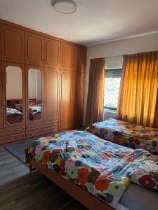 a bedroom with two beds and wooden cabinets at Abdoun ground floor apartment in Amman +13 photos