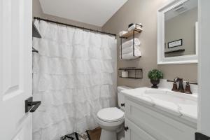 a white bathroom with a toilet and a sink at Lakeside Lodge on Bluegill- Arcade, Dock, FirePit in Eatonton +88 photos