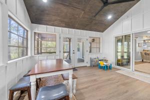 a dining room with a table and some windows at Lakeside Lodge on Bluegill- Arcade, Dock, FirePit in Eatonton