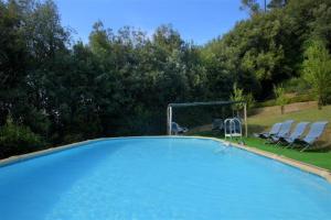 a large swimming pool with two chairs at Villa Bruschetti in Empoli