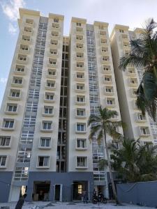 un grand bâtiment avec des palmiers devant dans l'établissement Ocean Paradise Luxury, à Nikawatawana