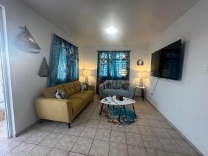 een woonkamer met een bank en een tafel bij White House Paradises in Cabo Rojo